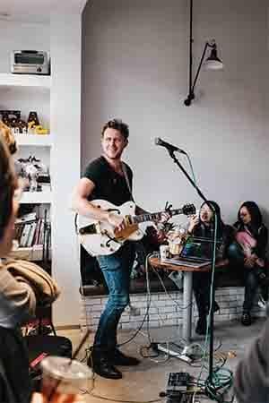 A man playing guitar in a small space